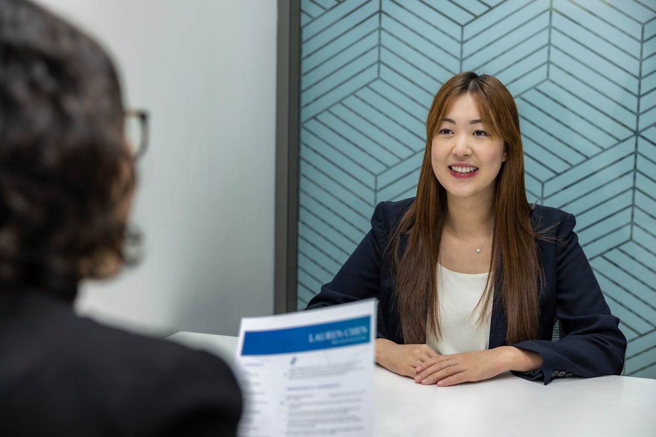 our-experience Young woman in a business meeting with an interviewer, showcasing confidence and professionalism.
