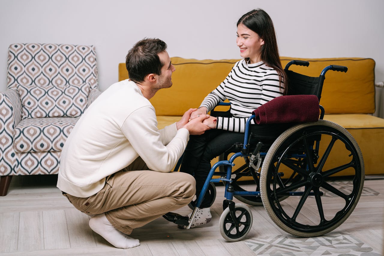 Man holds woman's hands, sharing a warm and supportive moment indoors.